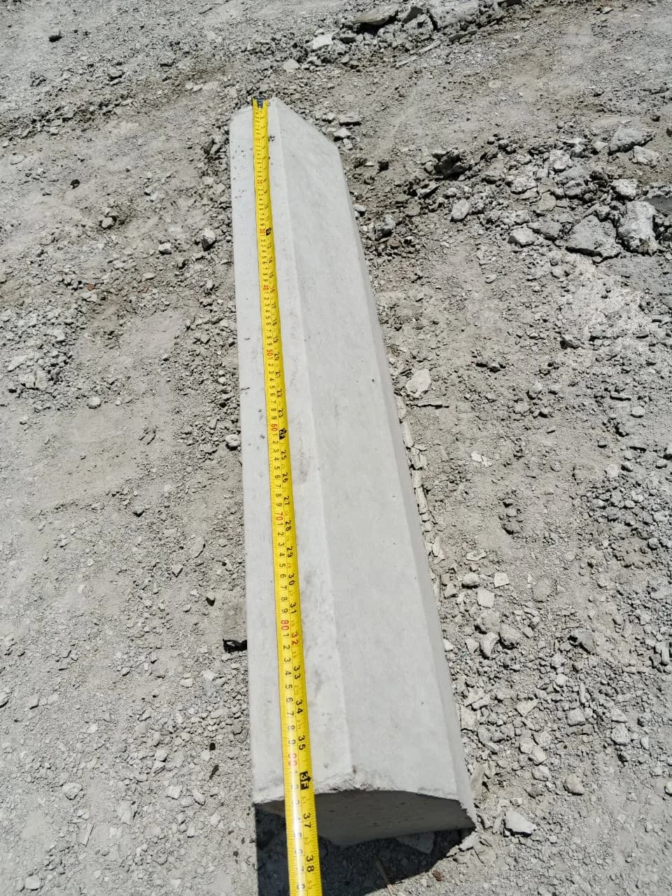 Cubstone kerb measured against a tape to show the cast dimension