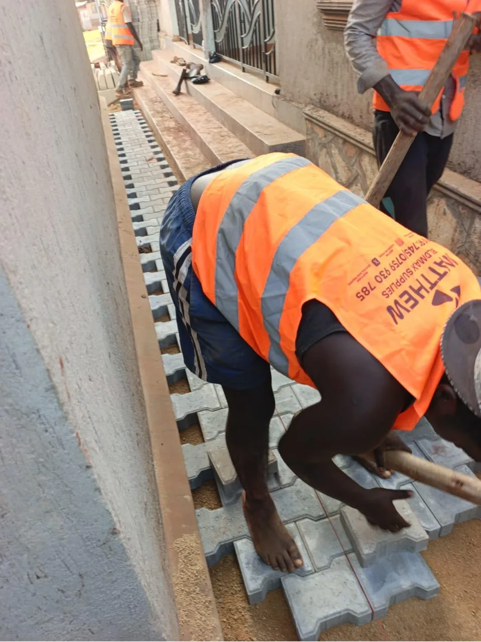 Crew in branded Matthew vests laying Double T pavers on site