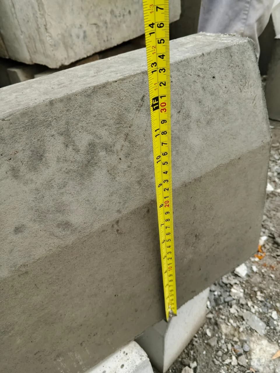 Chamfered concrete kerb units stacked on a pallet at the yard